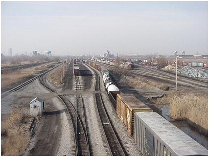 Photo taken from the Tift Street overpass of the Tifft Street Rail Yards showing one of the region's major rail corridors, the City of Buffalo skyline and the CP Draw Bridge which traverses the Buffalo River are visible in the background.